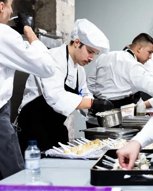Juan Pablo Pallavidini emplatando en una cocina profesional junto a su equipo